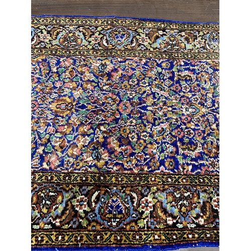 1038 - A North West Persian part silk blue ground rug, 89cm x 58cm