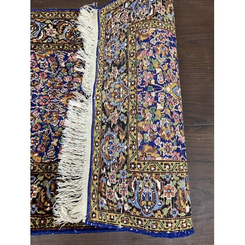 1038 - A North West Persian part silk blue ground rug, 89cm x 58cm