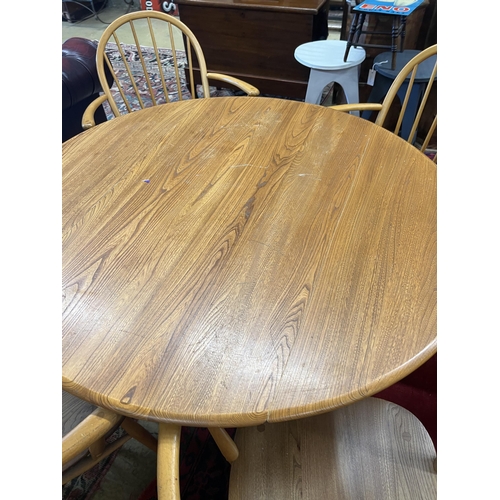 1058 - An Ercol oval elm drop leaf dining table, length 123cm extended, width 113cm, height 71cm and four E... 