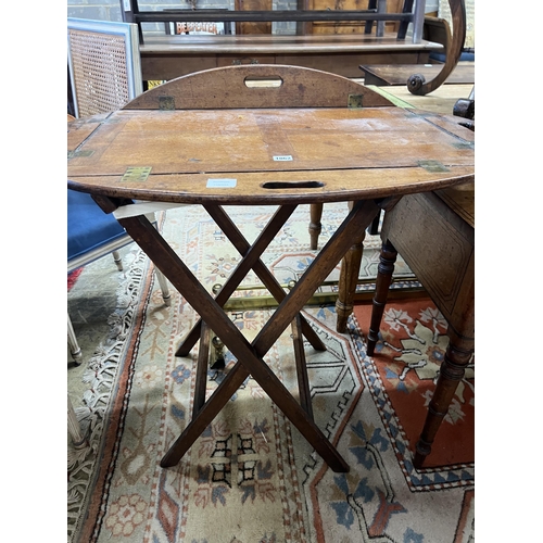 1062 - A Victorian brass mounted oval mahogany folding butler's tray / table on stand, width 90cm, height 8... 