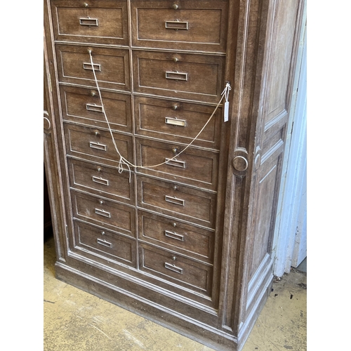 1095 - An early 20th century French oak notaries cabinet with 20 fall front compartments, width 125cm, dept... 