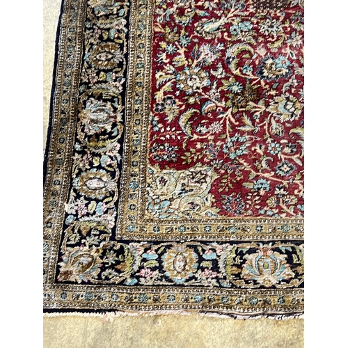 1105 - A Tabriz part silk burgundy ground rug, 218 x 150cm