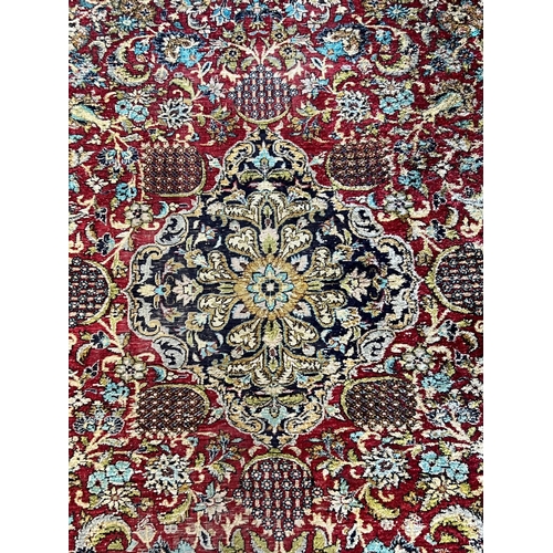 1105 - A Tabriz part silk burgundy ground rug, 218 x 150cm