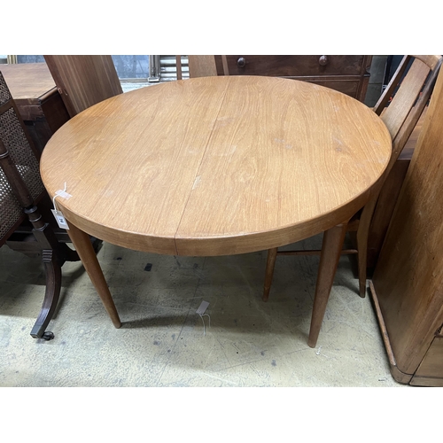 1119 - A mid century circular teak extending dining table, length 130cm extended, two spare leaves, depth 1... 