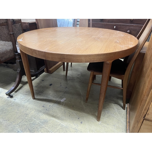 1119 - A mid century circular teak extending dining table, length 130cm extended, two spare leaves, depth 1... 