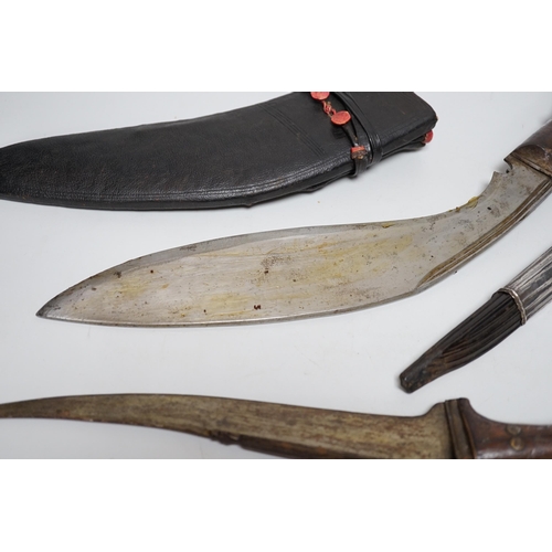 1253 - Two Sinhalese daggers and a kukri, a silver inlaid Kirichchiya dagger, together with another in a sc... 