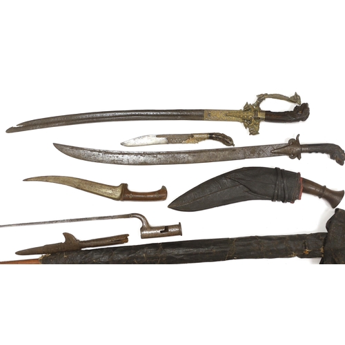 1253 - Two Sinhalese daggers and a kukri, a silver inlaid Kirichchiya dagger, together with another in a sc... 