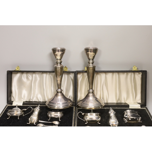 1848 - Two modern cased silver three piece cruet sets, with spoons and a pair of modern silver candlesticks... 