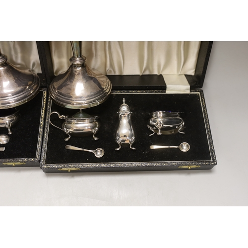 1848 - Two modern cased silver three piece cruet sets, with spoons and a pair of modern silver candlesticks... 