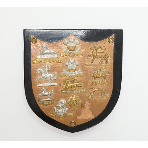 1285 - A collection of Military cap badges and buttons, with lugs removed and glued to beaten copper shield... 