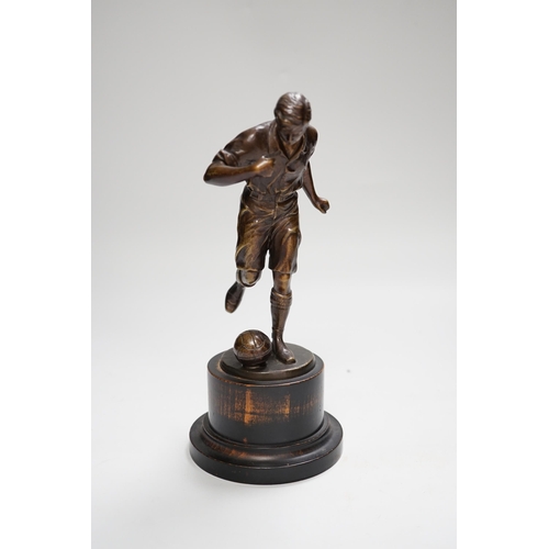 1401 - A pre-war bronze figure of a footballer, raised on a circular ebonies wood base, 23cm high