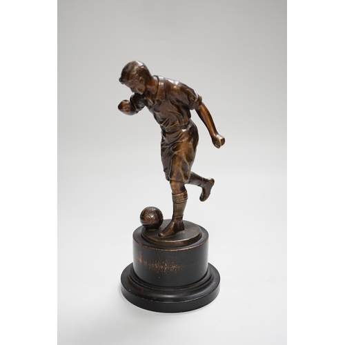 1401 - A pre-war bronze figure of a footballer, raised on a circular ebonies wood base, 23cm high