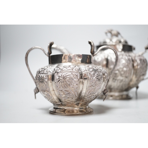 1842 - An Indian embossed white metal three piece tea set, with cobra handles and elephant finial, 25.7oz.... 