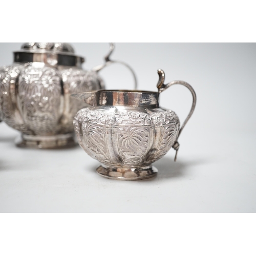 1842 - An Indian embossed white metal three piece tea set, with cobra handles and elephant finial, 25.7oz.... 