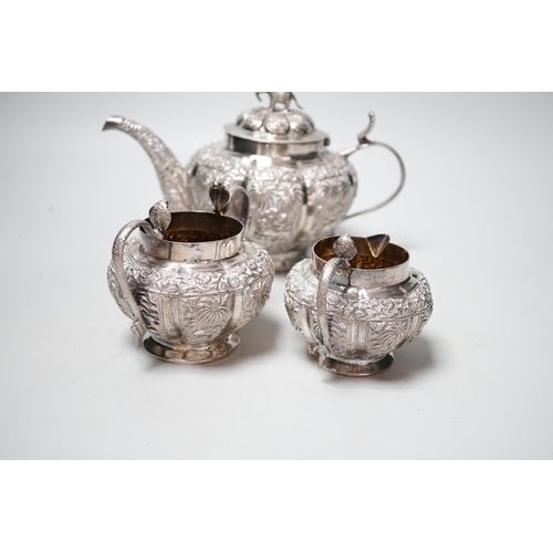 1842 - An Indian embossed white metal three piece tea set, with cobra handles and elephant finial, 25.7oz.... 