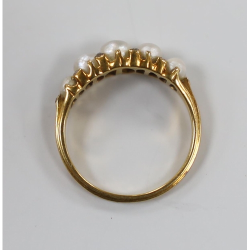 1923 - An Edwardian yellow metal and graduated split pearl set half hoop ring, with diamond chip spacers, s... 