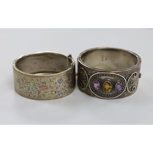 1946 - A  late Victorian silver and three stone amethyst and citrine set hinged bangle and a later white me... 