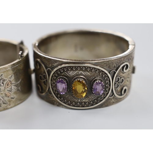 1946 - A  late Victorian silver and three stone amethyst and citrine set hinged bangle and a later white me... 