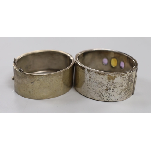 1946 - A  late Victorian silver and three stone amethyst and citrine set hinged bangle and a later white me... 