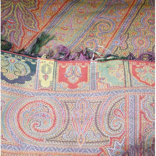 306 - A 19th century woven multi coloured wool and silk Paisley shawl,  with large all over paisley tear d... 