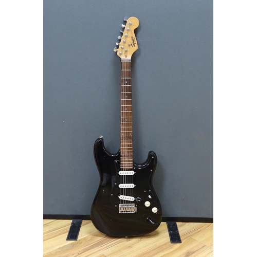 309 - A cased Squier Strat by Fender electric guitar with rosewood neck and balance lacquer body, together... 