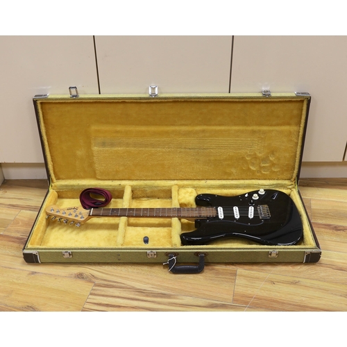 309 - A cased Squier Strat by Fender electric guitar with rosewood neck and balance lacquer body, together... 