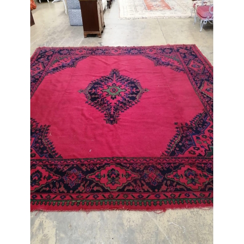 63 - An Afghan red ground carpet, 330 x 314cm