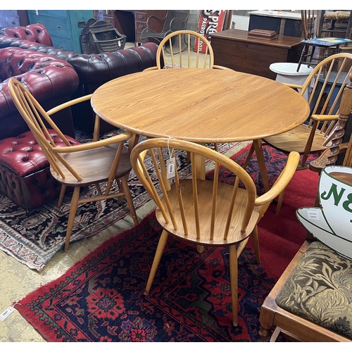 69 - An Ercol oval elm drop leaf dining table, length 123cm extended, width 113cm, height 71cm and four E... 