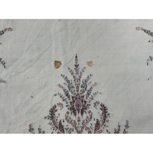 1300 - A late 19th century wool woven Paisley shawl with cream central cartouche (some damage)