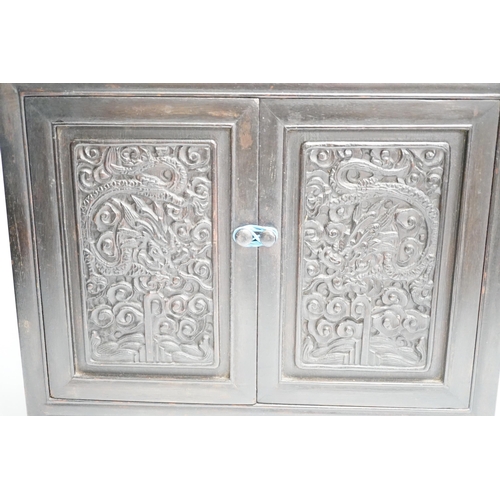 1321 - An early 20th century Chinese hongmu cabinet with carved cupboard doors, 61cm high