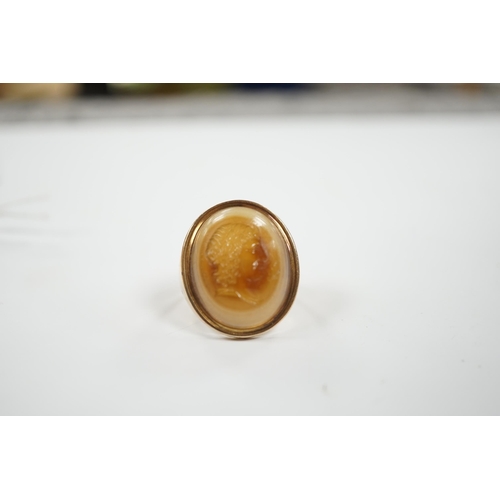 1944 - An early 20th century yellow metal and banded agate intaglio ring, carved with the head of a gentlem... 