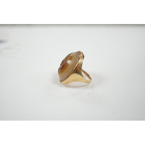 1944 - An early 20th century yellow metal and banded agate intaglio ring, carved with the head of a gentlem... 