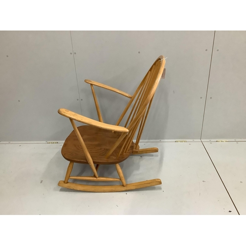 1066 - An Ercol elm and beech comb back rocking armchair, width 73cm, depth 78cm, height 95cm