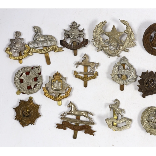 322 - Twenty military cap badges including Bedfordshire, West Yorkshire, Cornwall, East Lancashire, the Ro... 