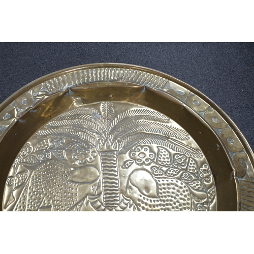 441 - An embossed brass table top/ tray, 74cm diameter