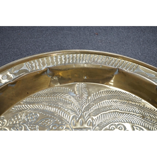 441 - An embossed brass table top/ tray, 74cm diameter