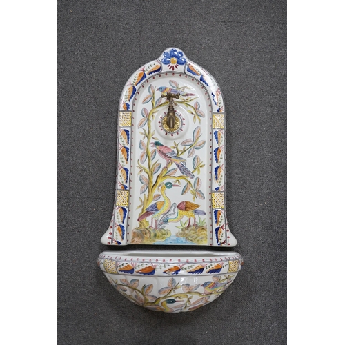 447 - A Portuguese pottery font and basin, hand painted with birds and flowers, 66cm high