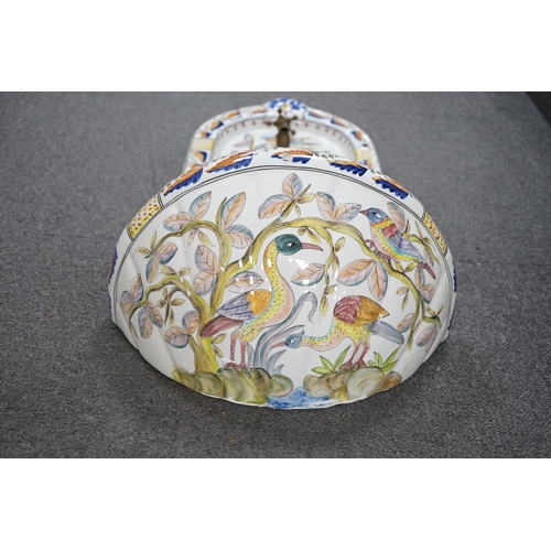 447 - A Portuguese pottery font and basin, hand painted with birds and flowers, 66cm high