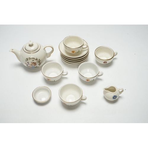 487 - A childs tea set comprising a teapot, five cups and saucers and a milk jug, teapot 8.5cm