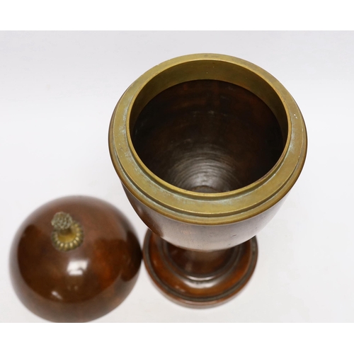 571 - A turned wood urn and cover with brass acorn finial, 37cm high