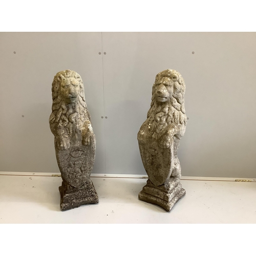 1042 - A pair of weathered composition stone heraldic lion garden ornaments, height 80cm