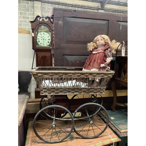 1057 - A Victorian style pram, width 80cm together with a modern bisque headed doll