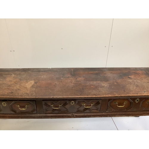 1143 - An 18th century oak low dresser fitted with geometric moulded drawers and brass handled over turned ... 