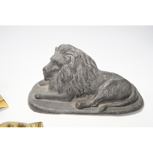 1266 - A 19th century brass recumbent lion, a similar cast iron lion and a smaller lion, largest 22cm wide... 