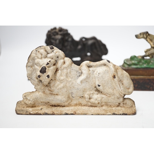 1285 - Two cast iron lion door stops and a painted dog door stop, 21cm wide