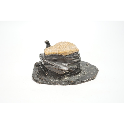 1333 - A bronze desk weight, a seal on rock, quartz mounted, 15cm wide