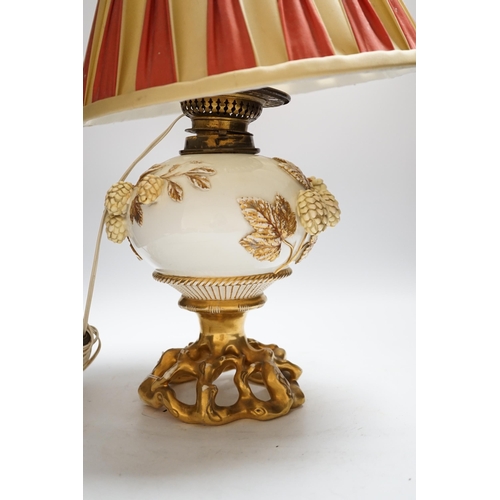 1426 - A Victorian porcelain oil lamp, probably Moore brothers, decorated with hops and gilt base, converte... 