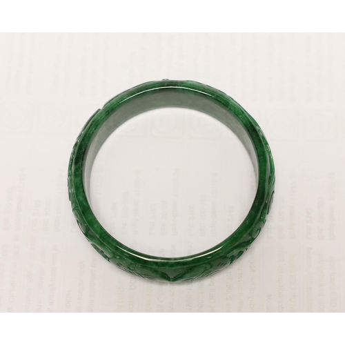 1451 - A Chinese carved jadeite bangle, 7.5cm in diameter