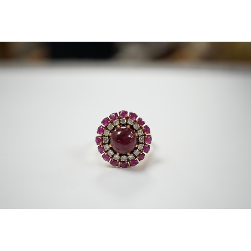 1975 - A yellow metal, ruby and diamond set circular cluster dress ring, with central cabochon ruby, size M... 