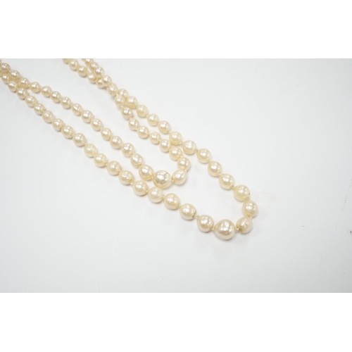 2046 - A double strand graduated cultured pearl necklace, with two colour paste set white metal clasp,  39c... 